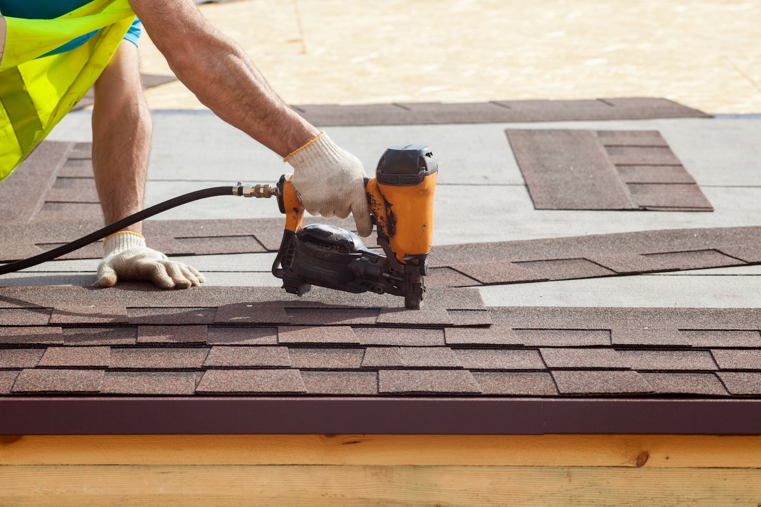 Roofer uses Nail Gun during roof replacement