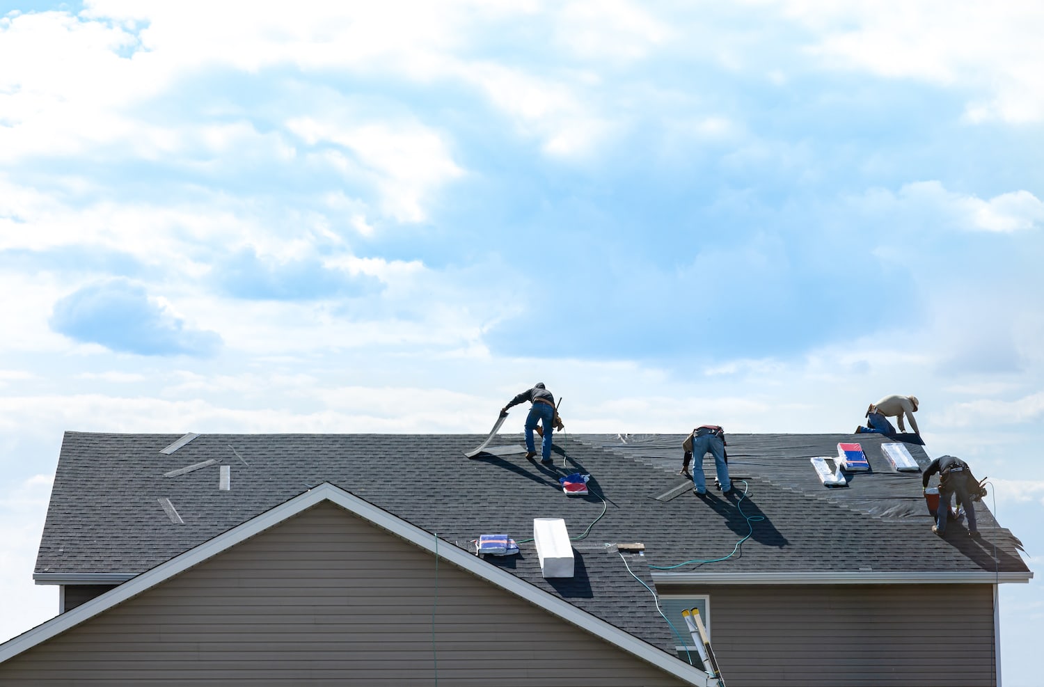 Roofing contractors on shingle roof finish full replacement