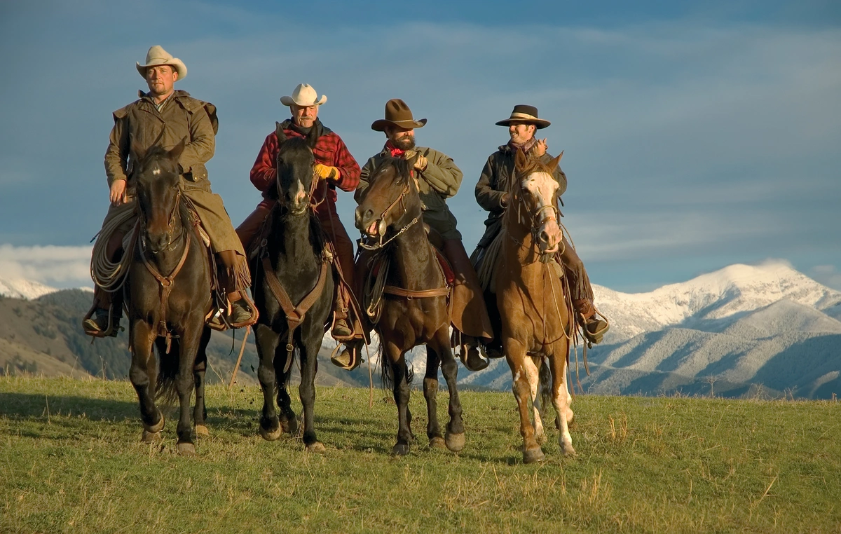 four cowboys on the range with horses