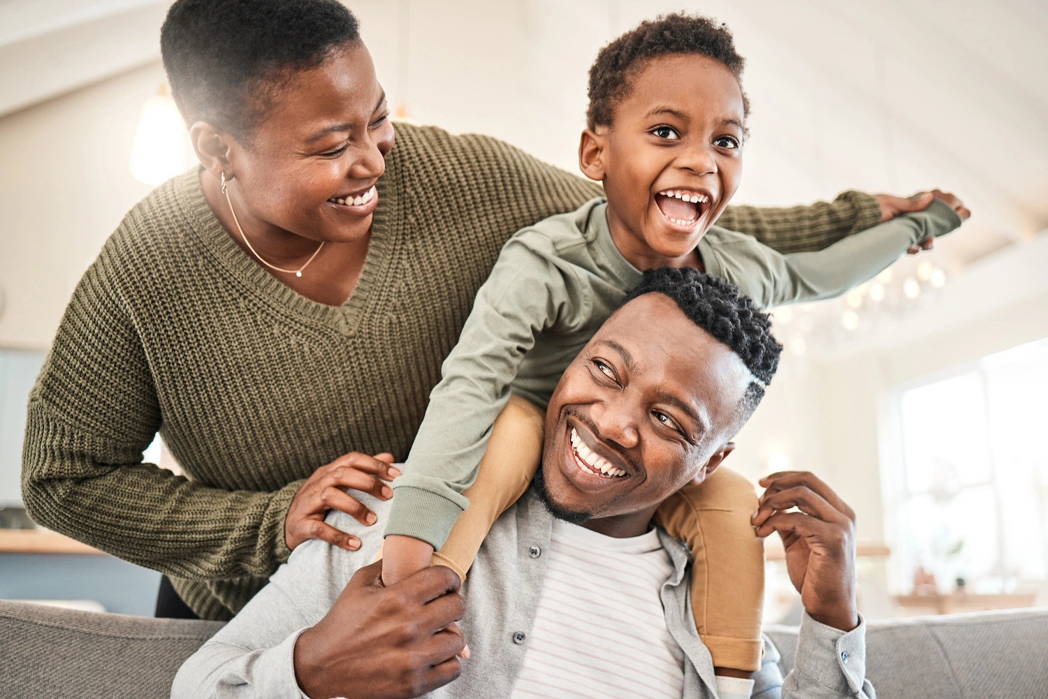 family of three smile with eachother in the comfort of their home