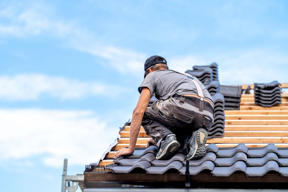 black roofing tiles being installed on roof