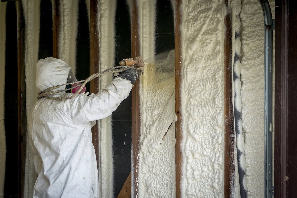 Worker using sprayfoam to insulation house walls