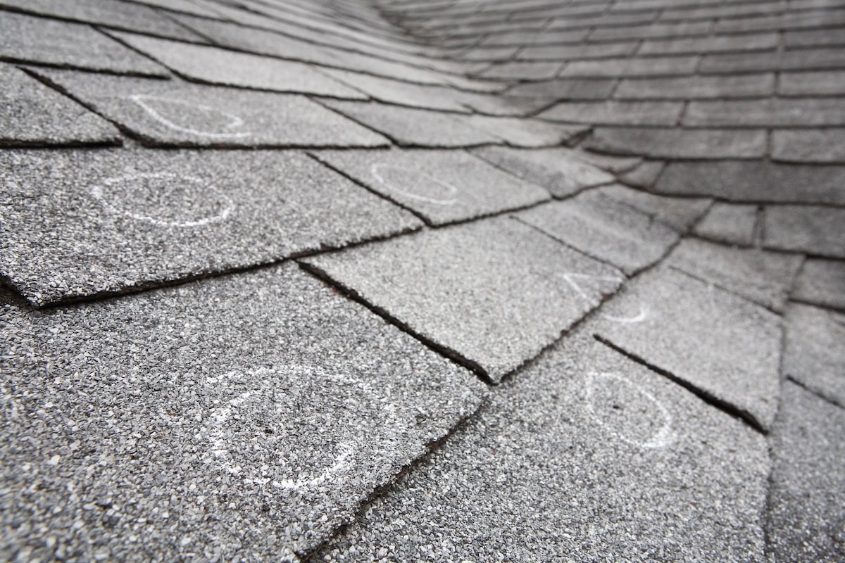Old roof with hail damage marked with chalk after inspection