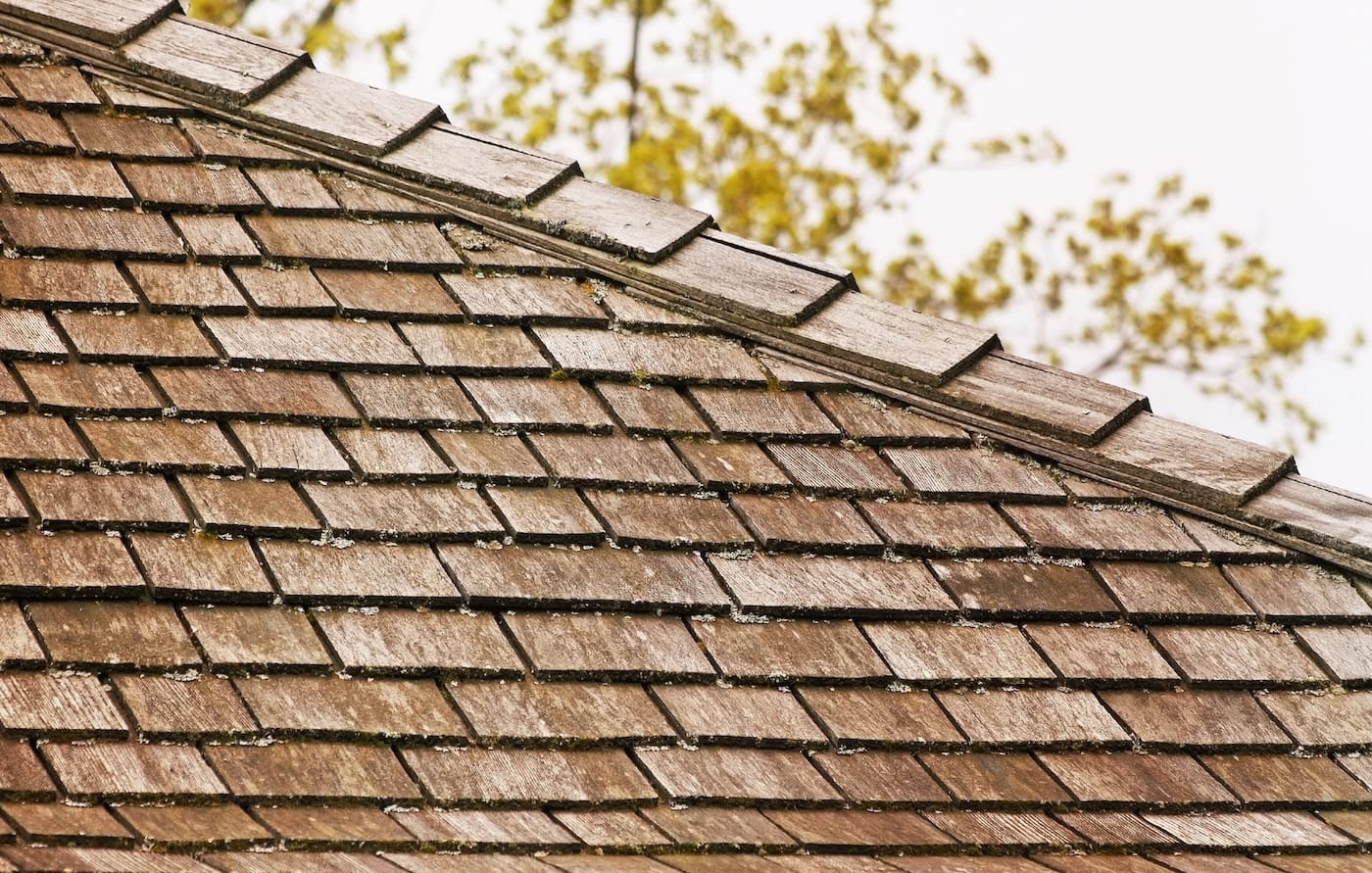 Cedar shingle roof with some tree debris and small amounts of moss