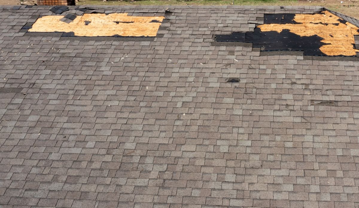 roof wind damage shingles missing leaving wooden plank visible